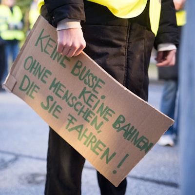Luisa Neubauer, Aktivistin von Fridays for Future, hält am BVG-Busdepot Cicerostraße ein Schild mit der Aufschrift «keine Busse, keine Bahnen, ohne Menschen, die sie fahren!» in der Hand.