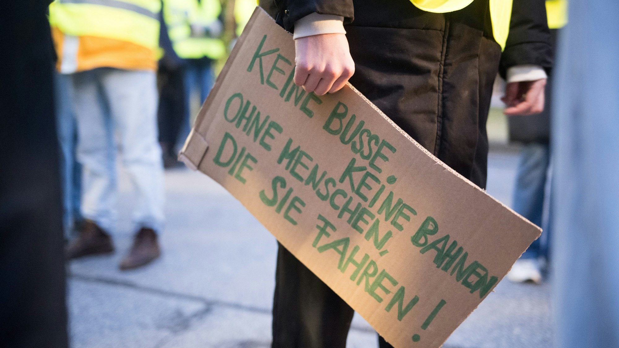 Luisa Neubauer, Aktivistin von Fridays for Future, hält am BVG-Busdepot Cicerostraße ein Schild mit der Aufschrift «keine Busse, keine Bahnen, ohne Menschen, die sie fahren!» in der Hand.