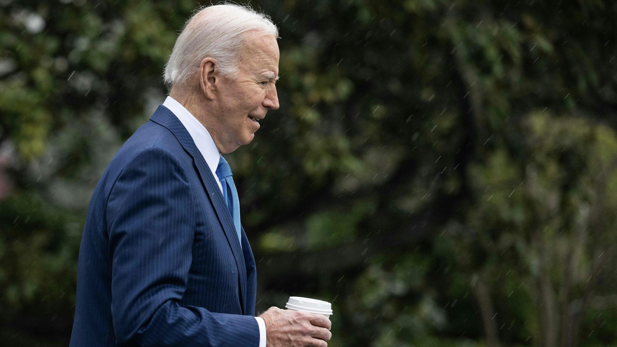 Joe Biden mit einem Becker Kaffee in seiner Hand.