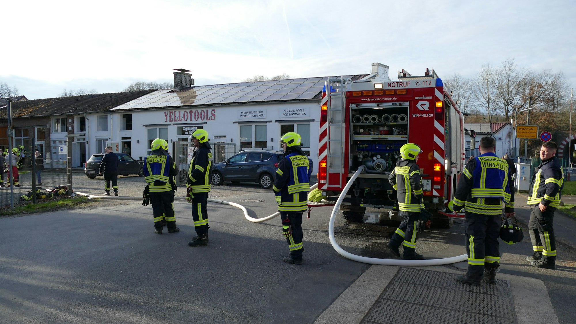 Feuerwehrleute stehen in Windeck vor deinem flachen Gebäude.