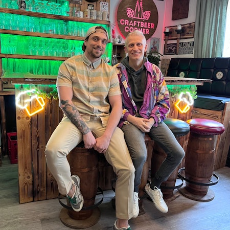 Zwei Männer sitzen in einer Kneipe auf Barhockern
