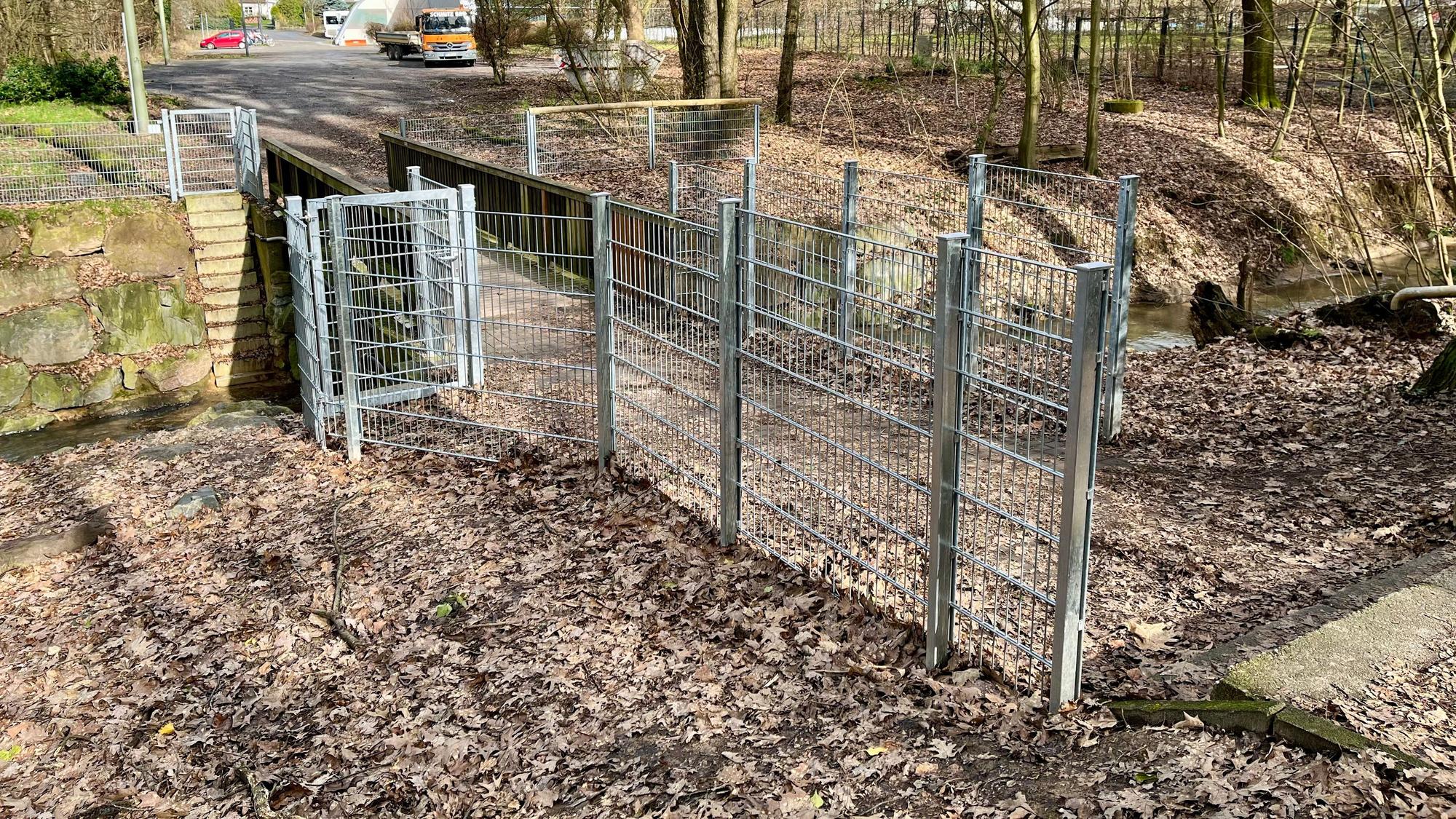 Die Brücke über den Wiembach in Leverkusen ist von einem hohen Zaun eingefasst, der nur einen schmalen Weg über die Brücke freilässt.