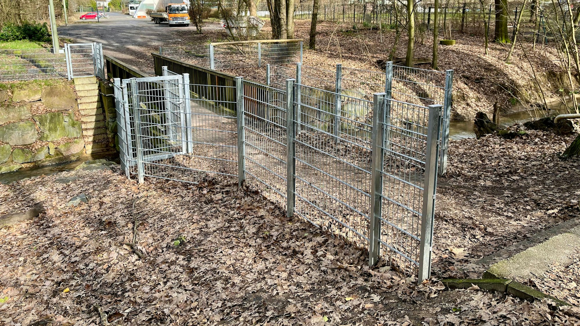 Die Brücke über den Wiembach in Leverkusen ist von einem hohen Zaun eingefasst, der nur einen schmalen Weg über die Brücke freilässt.