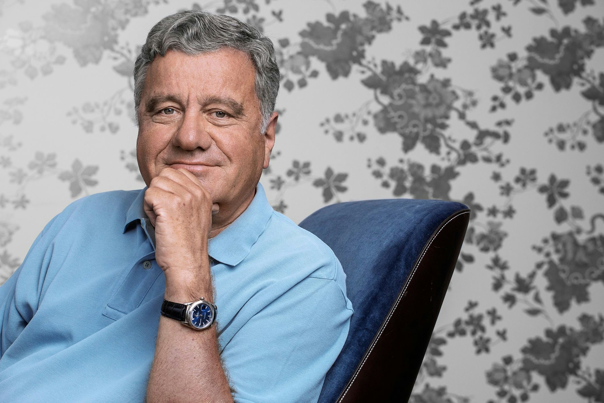 Raimund Wilhelmi auf einem Stuhl mit blauen Samt.