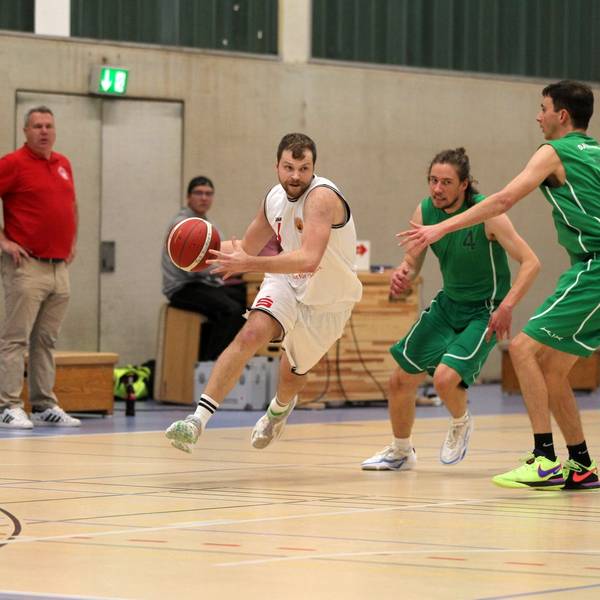 Basketballer Philipp Greuel läuft mit dem Ball, um ihn herum sind drei Gegenspieler.