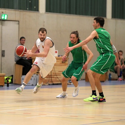 Basketballer Philipp Greuel läuft mit dem Ball, um ihn herum sind drei Gegenspieler.