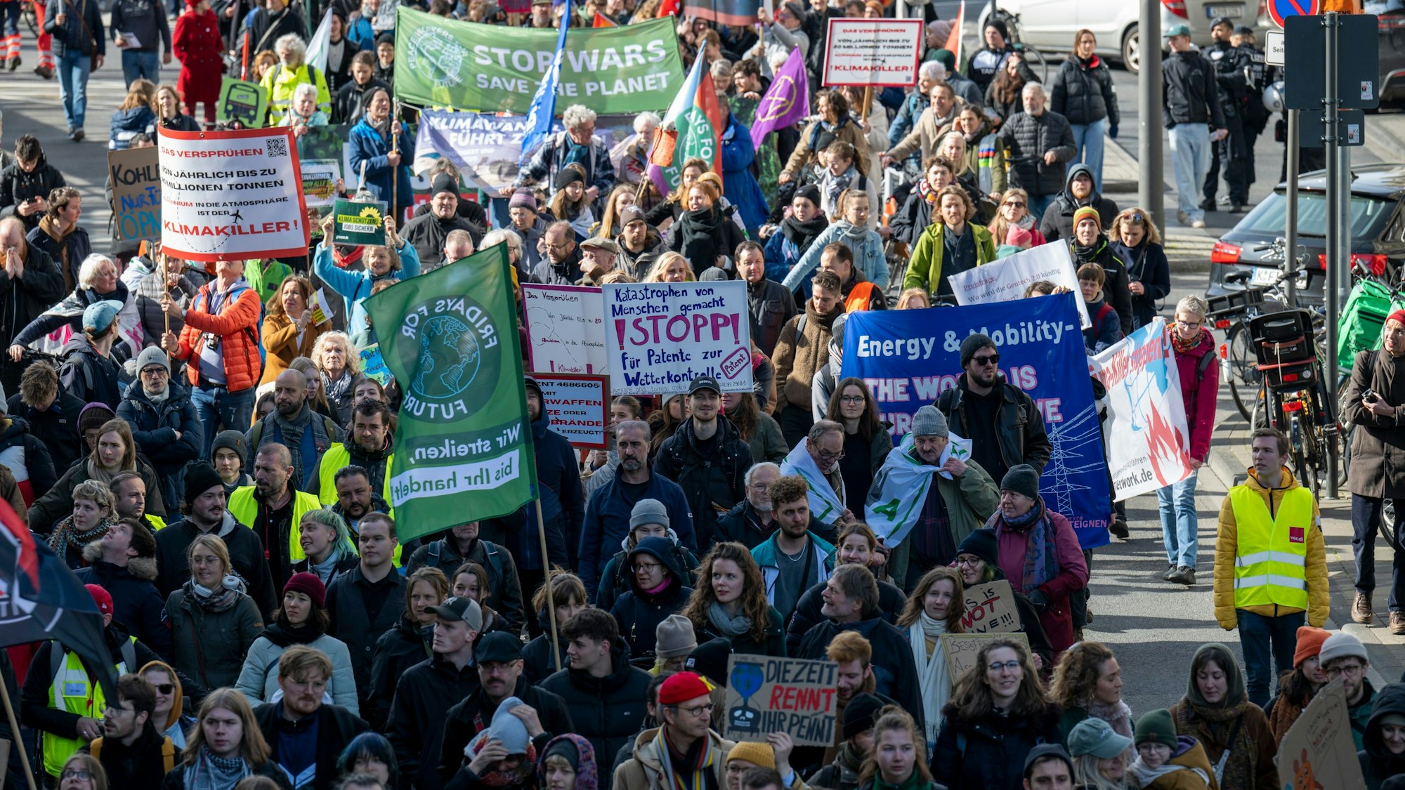 Menschen demonstrieren gemeinsam und halten Plakate von Fridays For Future und Verdi in die Luft.