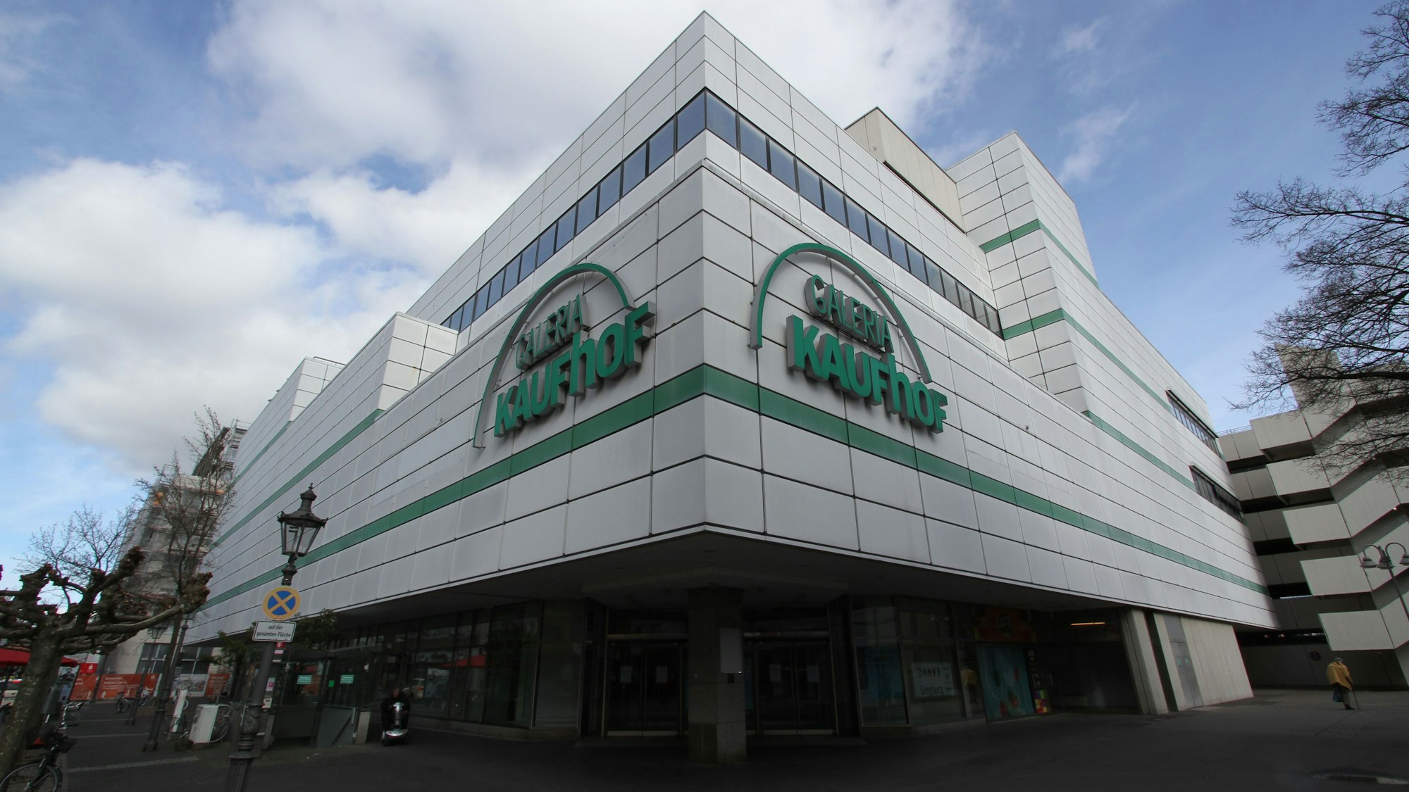 Ein leer stehendes Kaufhof-Gebäude mit weißer Fassade und grüner Reklameschrift