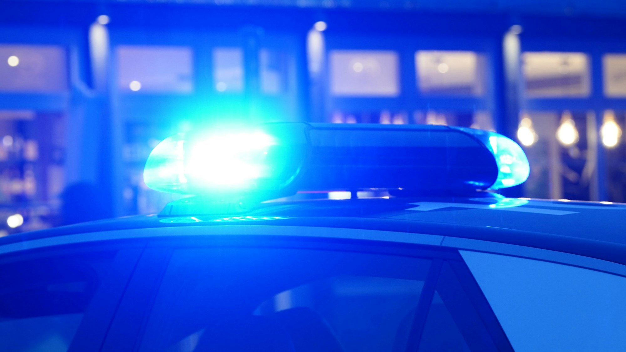 Ein Blaulicht leuchtet auf dem Dach eines Polizeiautos.