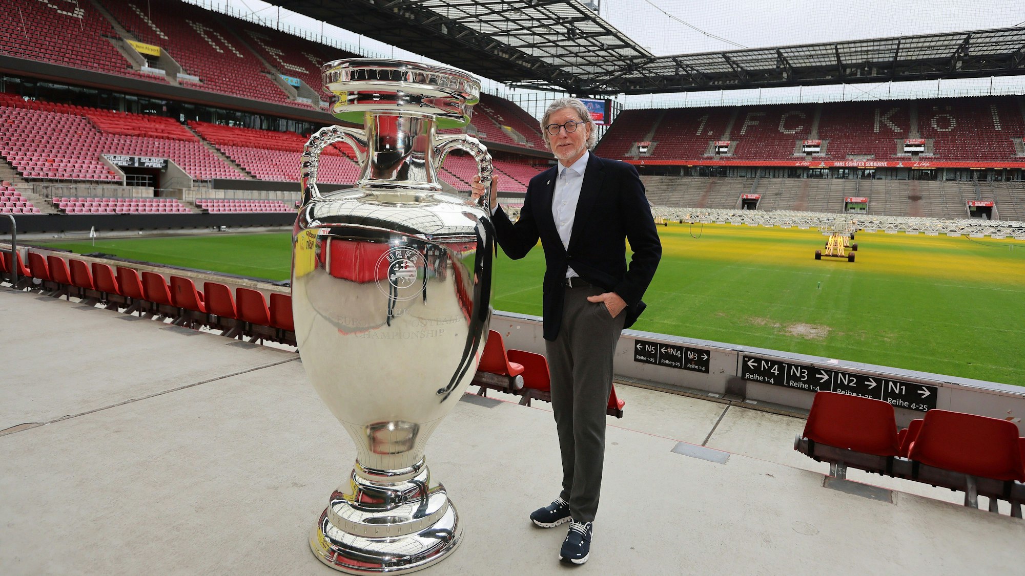 Toni Schumacher mit übergroßer Nachbildung vom EM-Pokal im Rhein-Energie-Stadion
