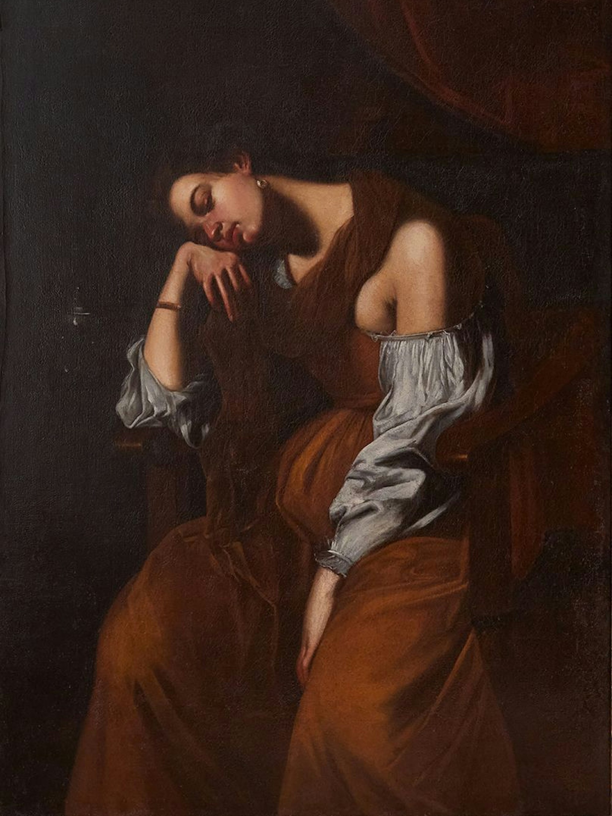 Eine junge Frau leidet im braunen Gewand.