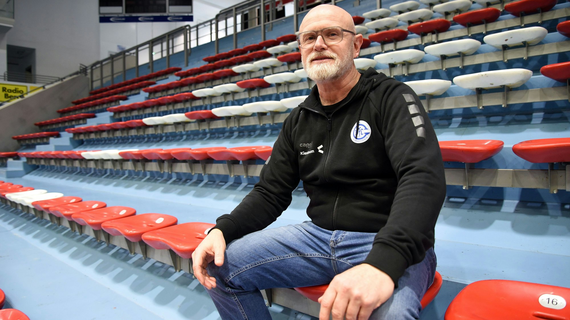 Jörg Bohrmann sitzt auf einem Rang in der Schwalbe-Arena.