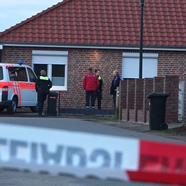 Einsatzkräfte stehen hinter einem Absperrband. Die Polizei ermittelt nach Schüssen im Landkreis Rotenburg wegen möglicher Kapitaldelikte. Es gebe zwei Tatorte - einen in einem Einfamilienhaus in Westervesede in der Gemeinde Scheeßel, außerdem in Bothel im Landkreis Rotenburg.