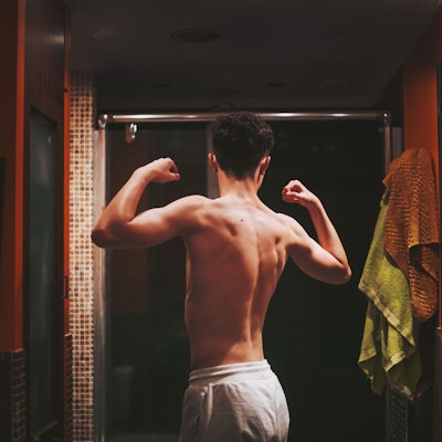 Ein Junge steht oberkörperfrei im Badezimmer