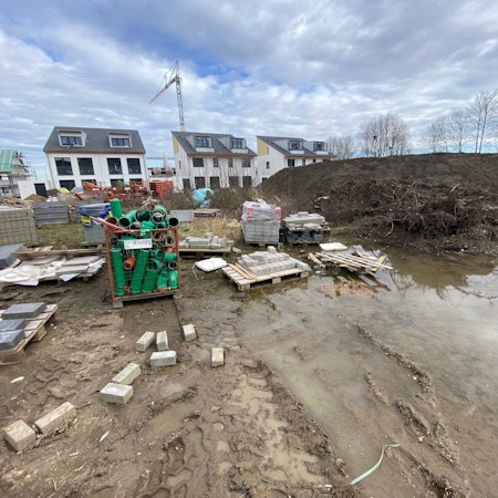 Zu sehen ist das Neubaugebiet als Baustelle, im Hintergrund Häuser.