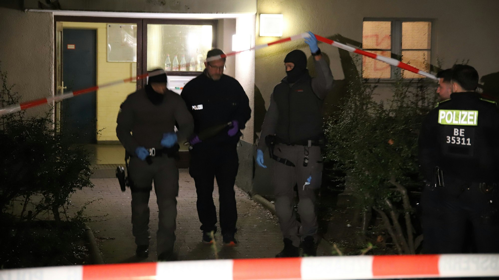 28.02.2024, Berlin: Beamte tragen einen als gefährlich eingestuften Gegenstand aus dem Wohnhaus der früheren RAF-Terroristin Daniela Klette, das wegen einer möglichen Gefahr geräumt wurde. Die frühere Terroristin der Roten Armee Fraktion (RAF), Daniela Klette, war am Montag in Berlin-Kreuzberg gefasst worden. (bestmögliche Qualität)