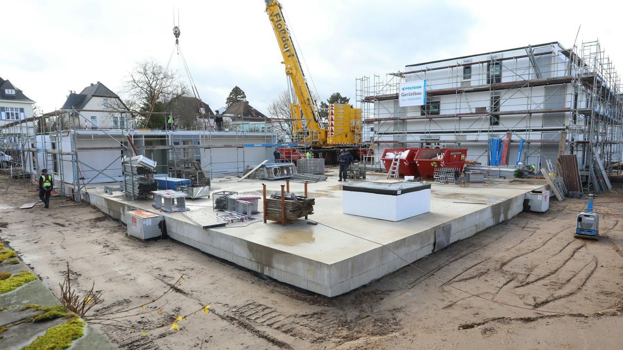 Eine Baustelle mit einem gelben Kran in der Mitte.