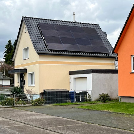 Fotovoltaik-Panele sind auf einem Hausdach montiert.