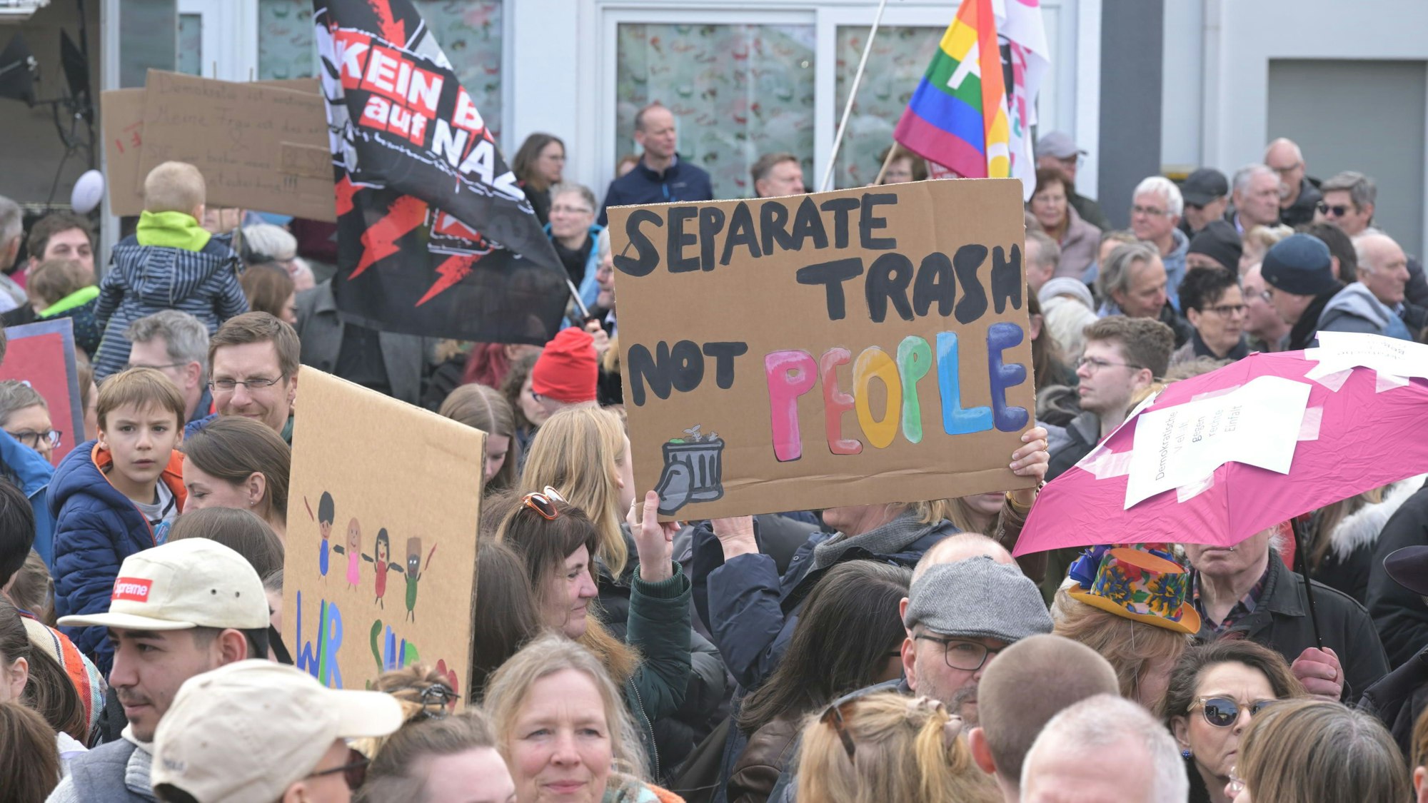 Demonstrierende auf dem Overather Bahnhofplatz halten Transparente in die Höhe.