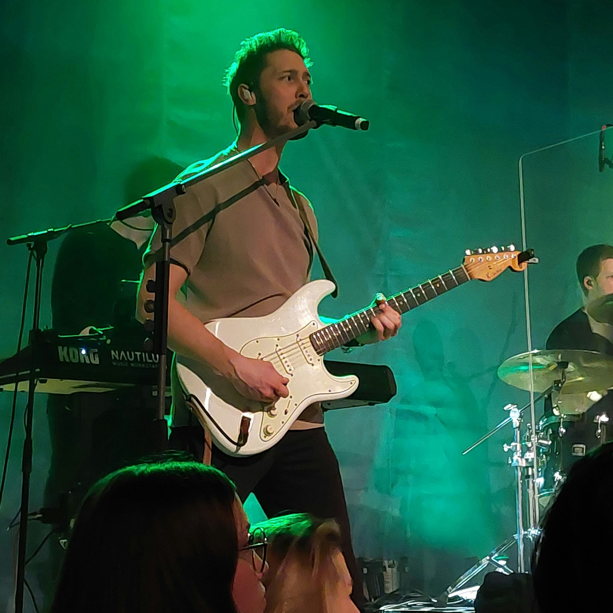 Mann an Gitarre und Mikrofon