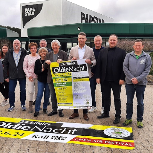 Bei der Vorstellung des Programms stellten sich die Organisatoren und Veranstalter vor dem Firmengebäude von Papstar zum Foto mit einem Veranstaltungsplakat auf.