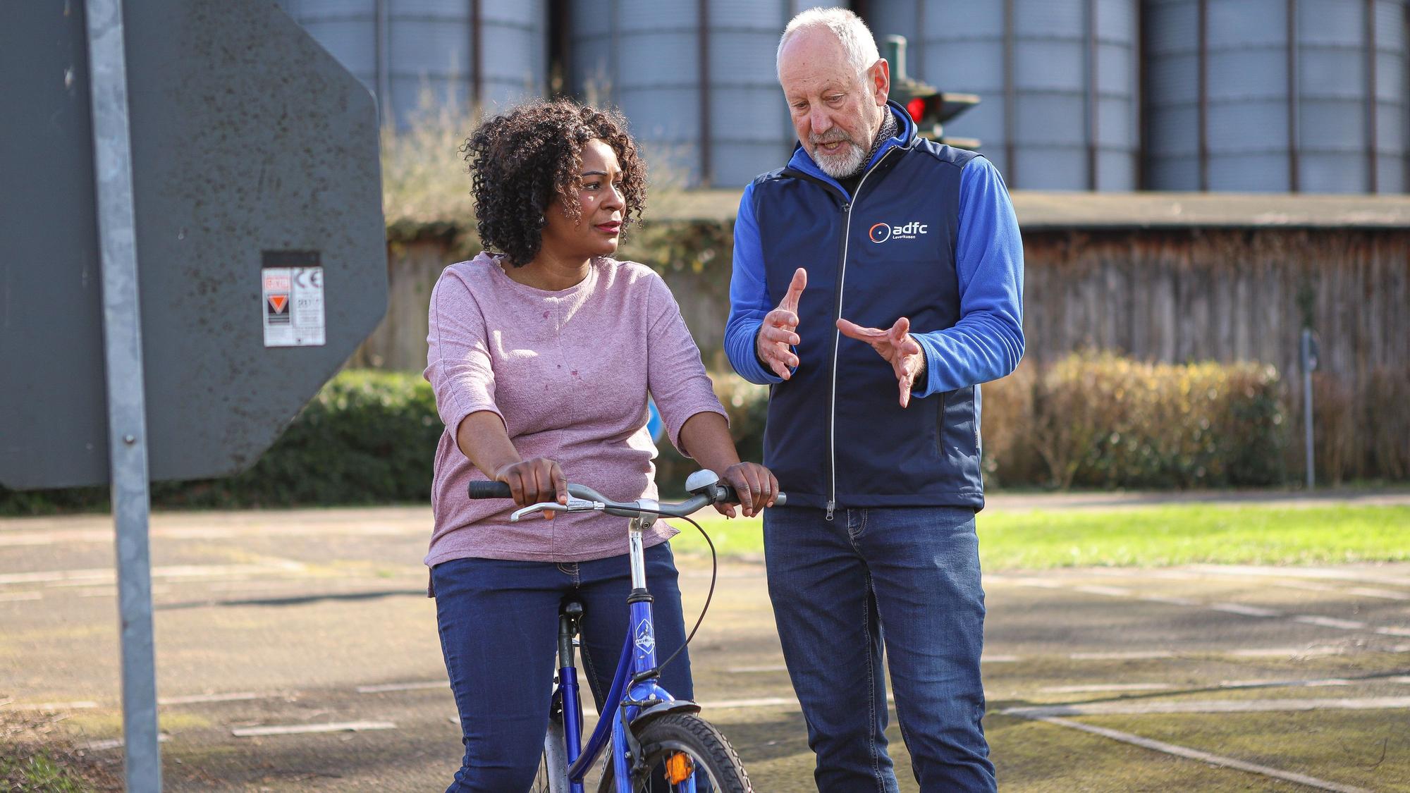 Ein Mann spricht mit einer Frau auf einem Fahrrad