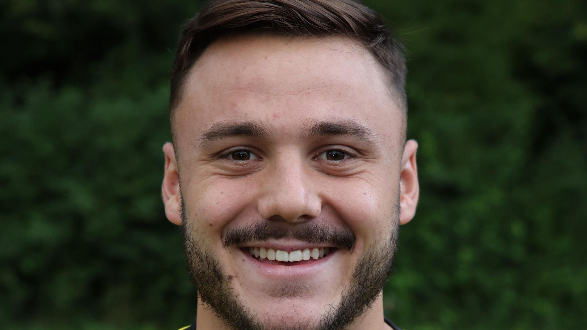 Fußballer Ömer Tokac von Eintracht Hohkeppel blickt lachend in die Kamera.