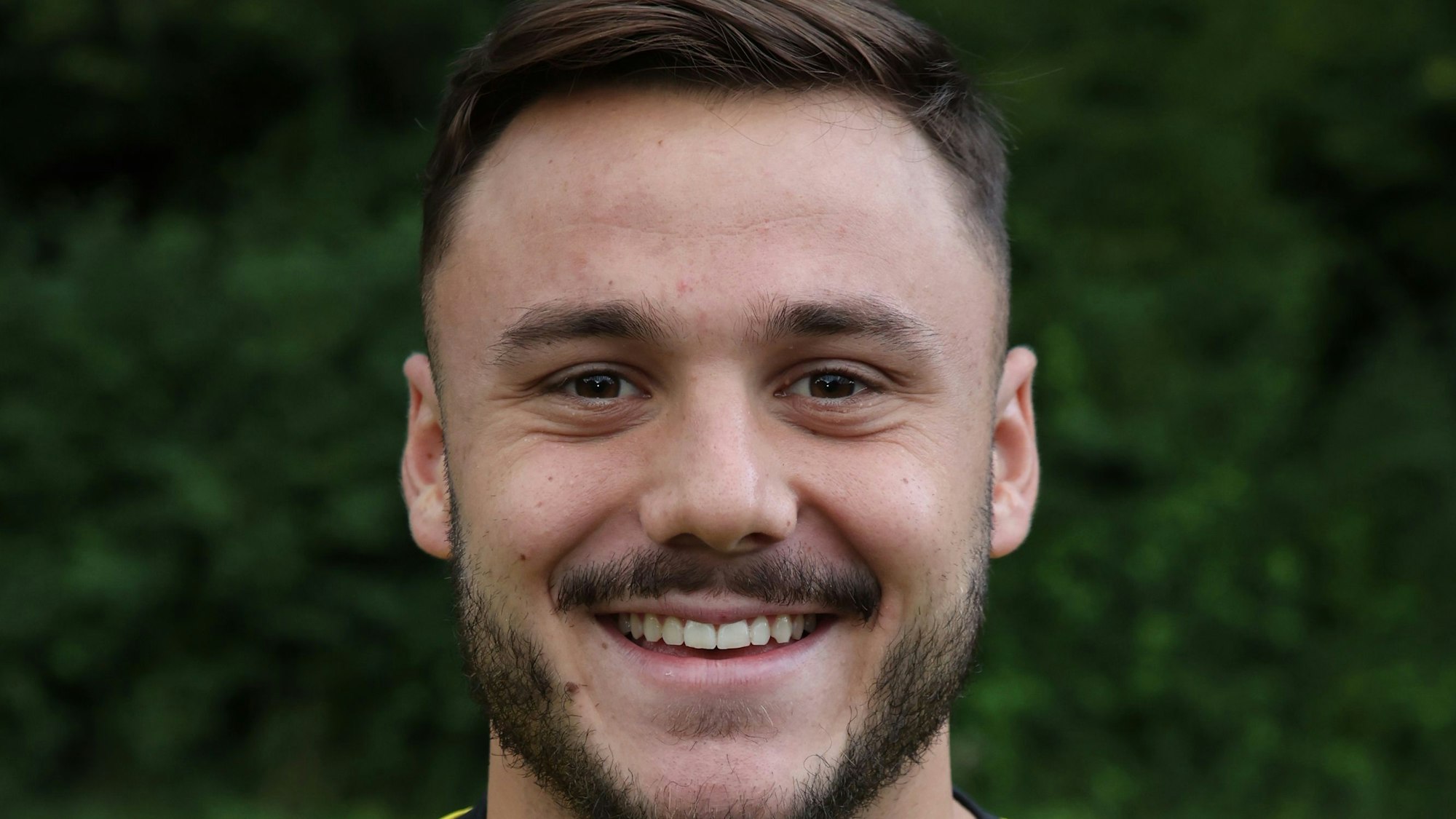 Fußballer Ömer Tokac von Eintracht Hohkeppel blickt lachend in die Kamera.