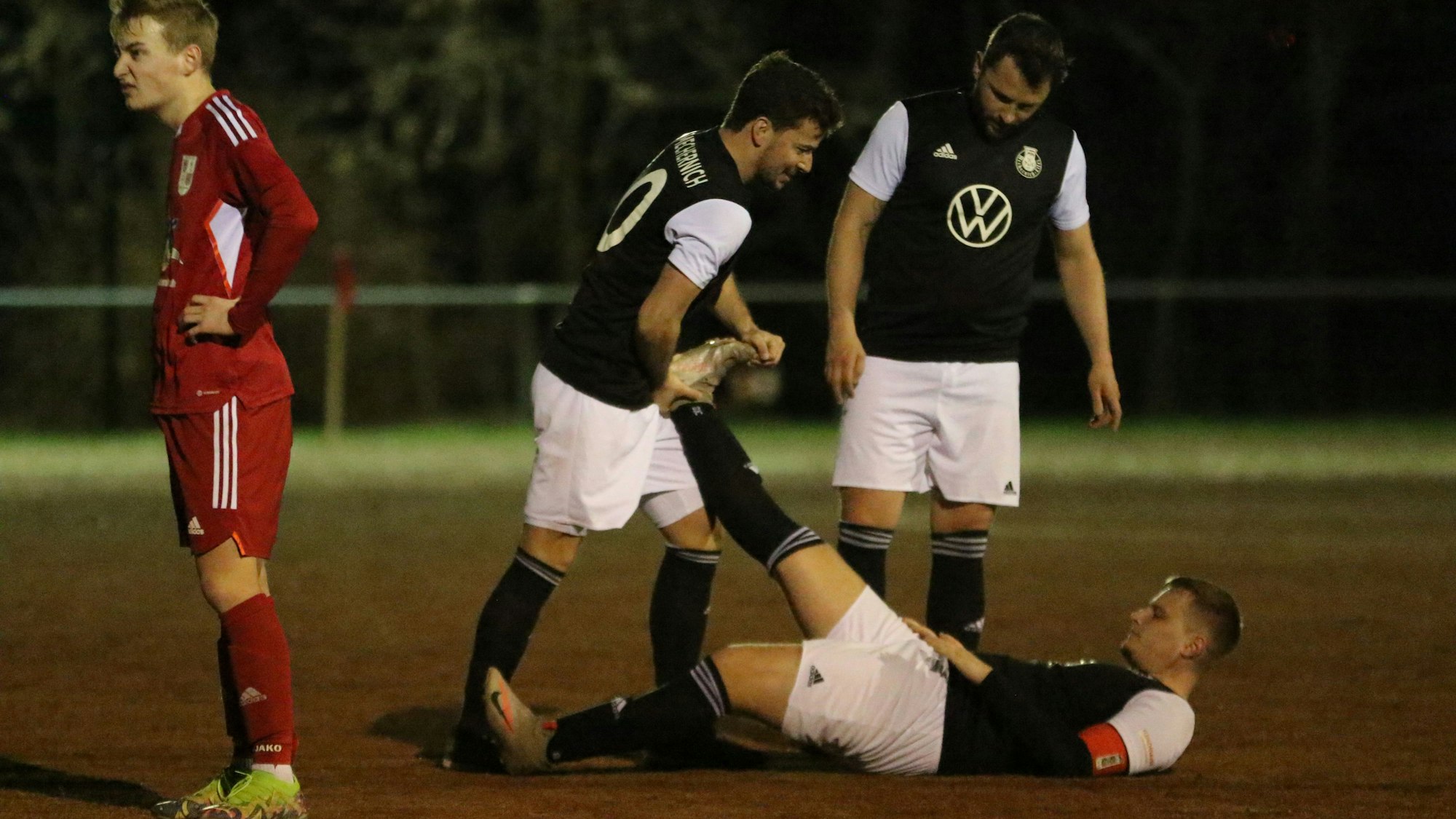 Mechernichs Andre Beaujean liegt mit einem Krampf auf dem Boden. Ein Mitspieler hilft ihm.