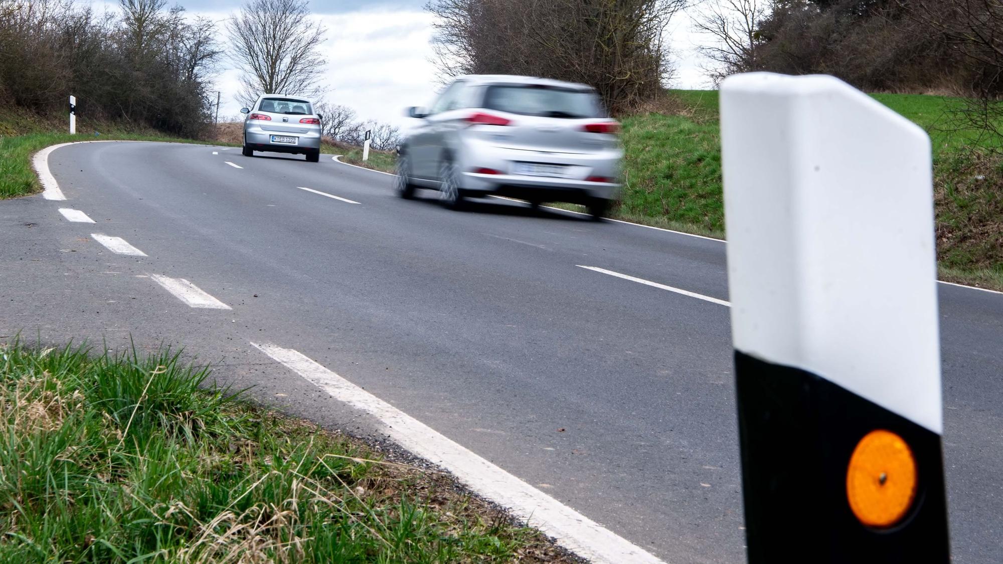 Zwei Autos fahren auf der Straße zwischen Iversheim und Wachendorf.