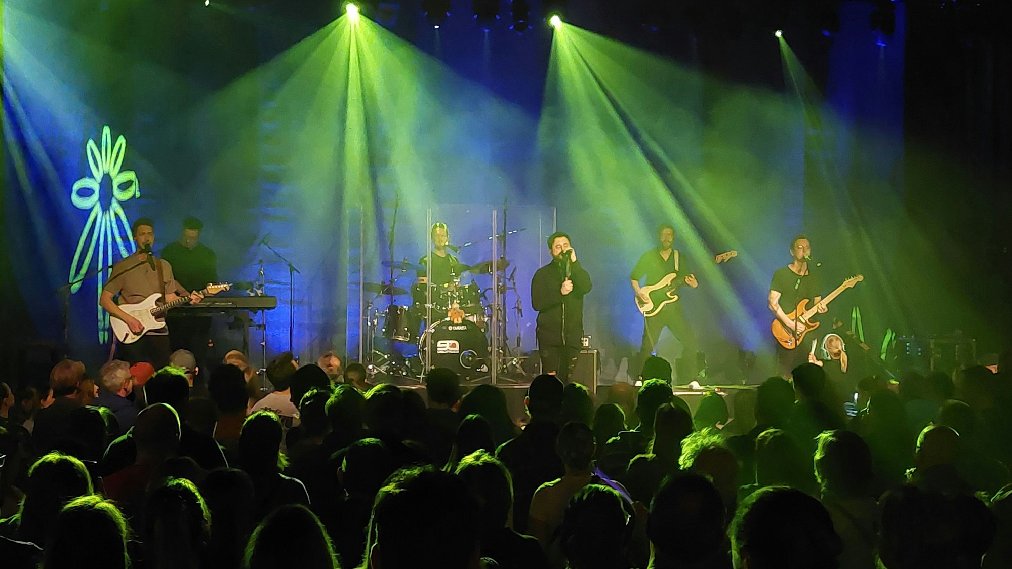 Fünf Musiker vor vollem Haus