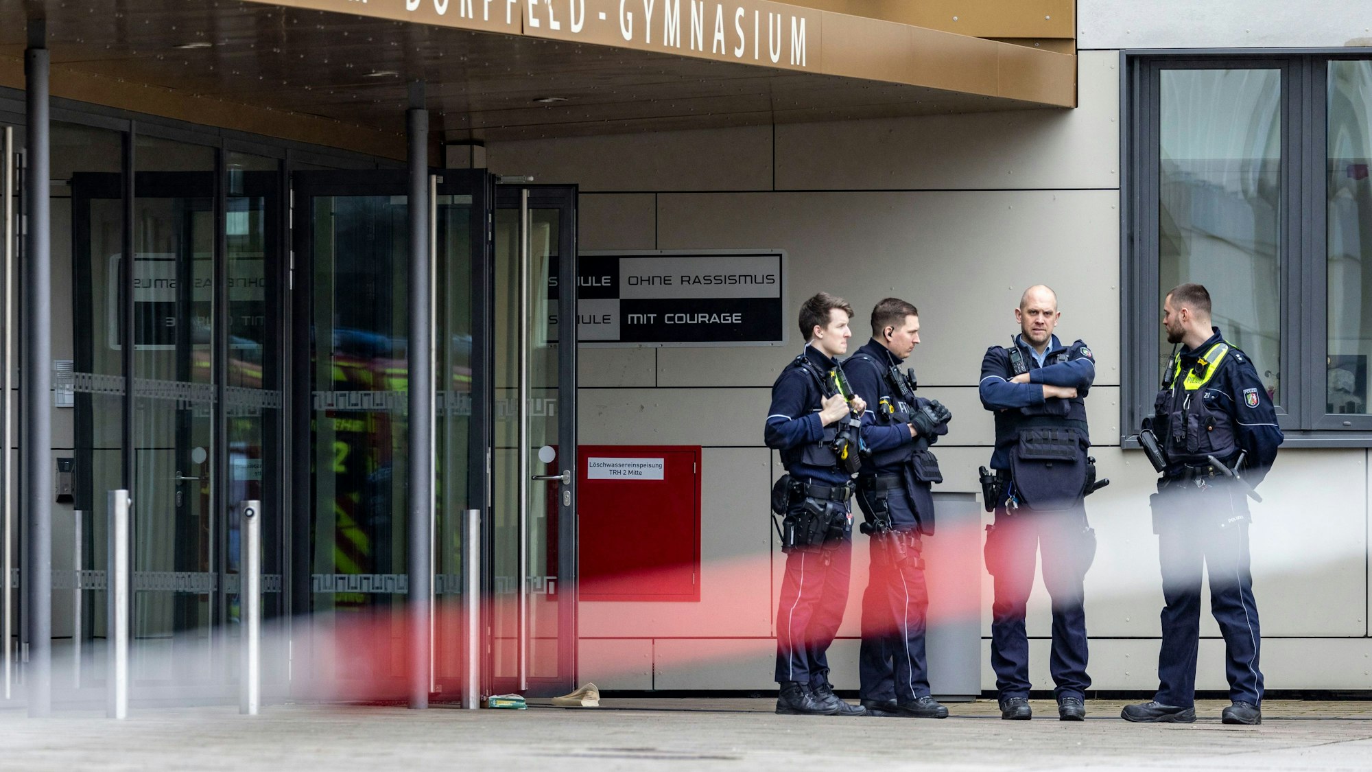 Polizisten stehen vor dem Gymnasium in Wuppertal, an dem am 22. Februar mehrere Schülerinnen und Schüler bei einer Messerattacke verletzt wurden.