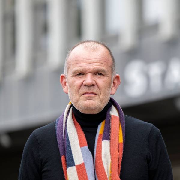 François-Xavier Roth steht vor dem Staatenhaus. Er trägt einen bunten Schal.