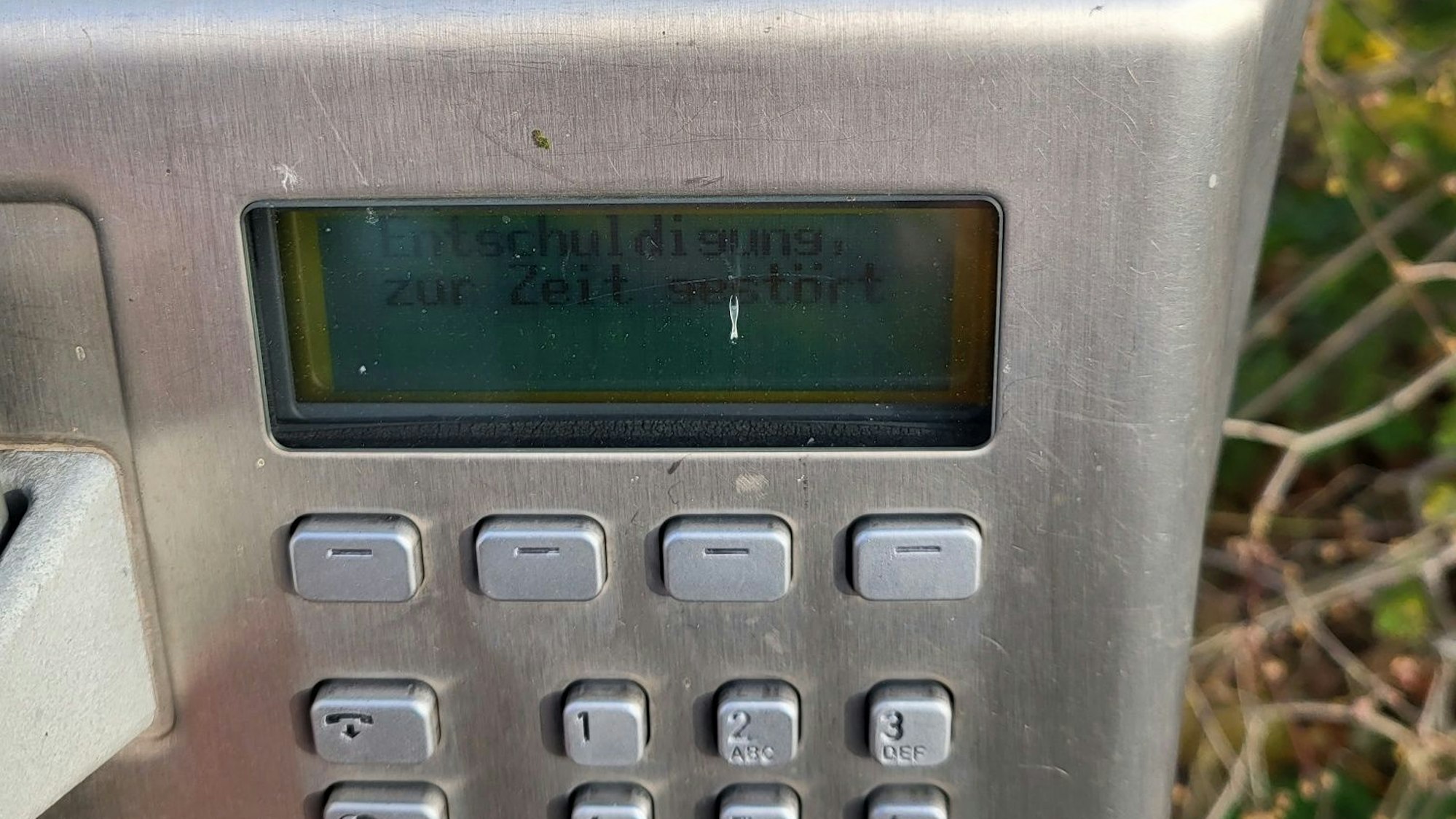 Öffentliches Telefon mit der Anzeige „Entschuldigung, zur Zeit gestört“