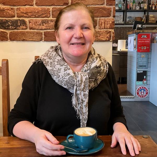 Frau im Café mit einer Tasse Cappuccino