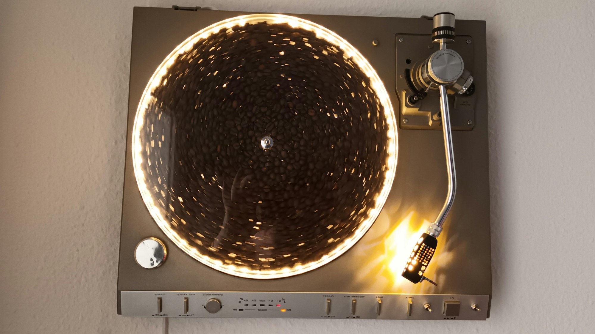 An der Wand hängt ein künstlerisch verfremdeter Plattenspieler