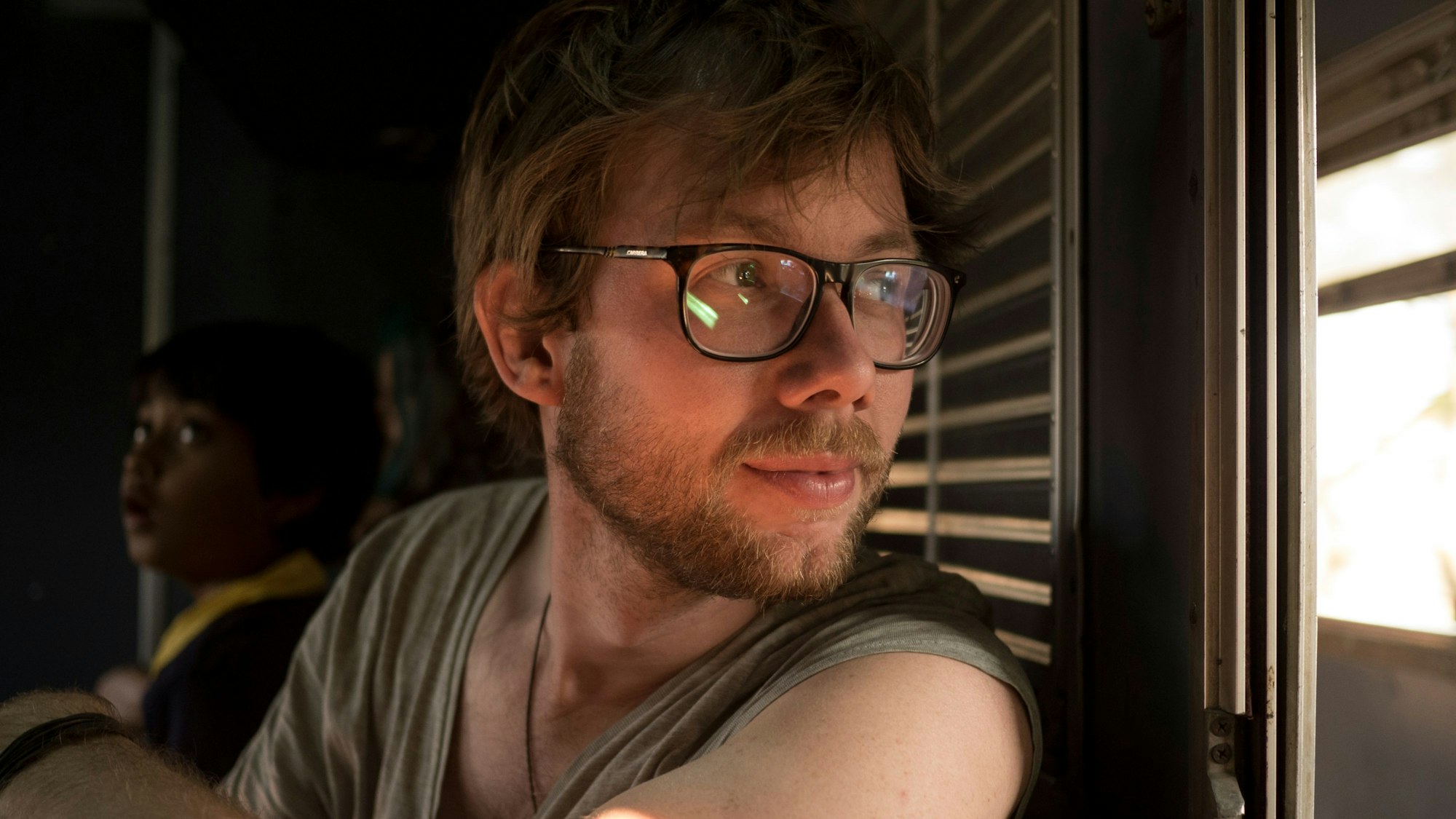 Johannes Klaus, Reiseblogger und Reiseverlagsleiter, ist in einem Zugabteil zu sehen. Er blickt aus dem Fenster.