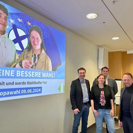Dezernent Alexander Lünenbach, Britta Meyer, Severin Schipp, OB Uwe Richrath und Oliver Gäcke, dr Leiter des Fachbereichs Bürger und Integration vor einer Leinwand mit der Europawahl-Kampagne