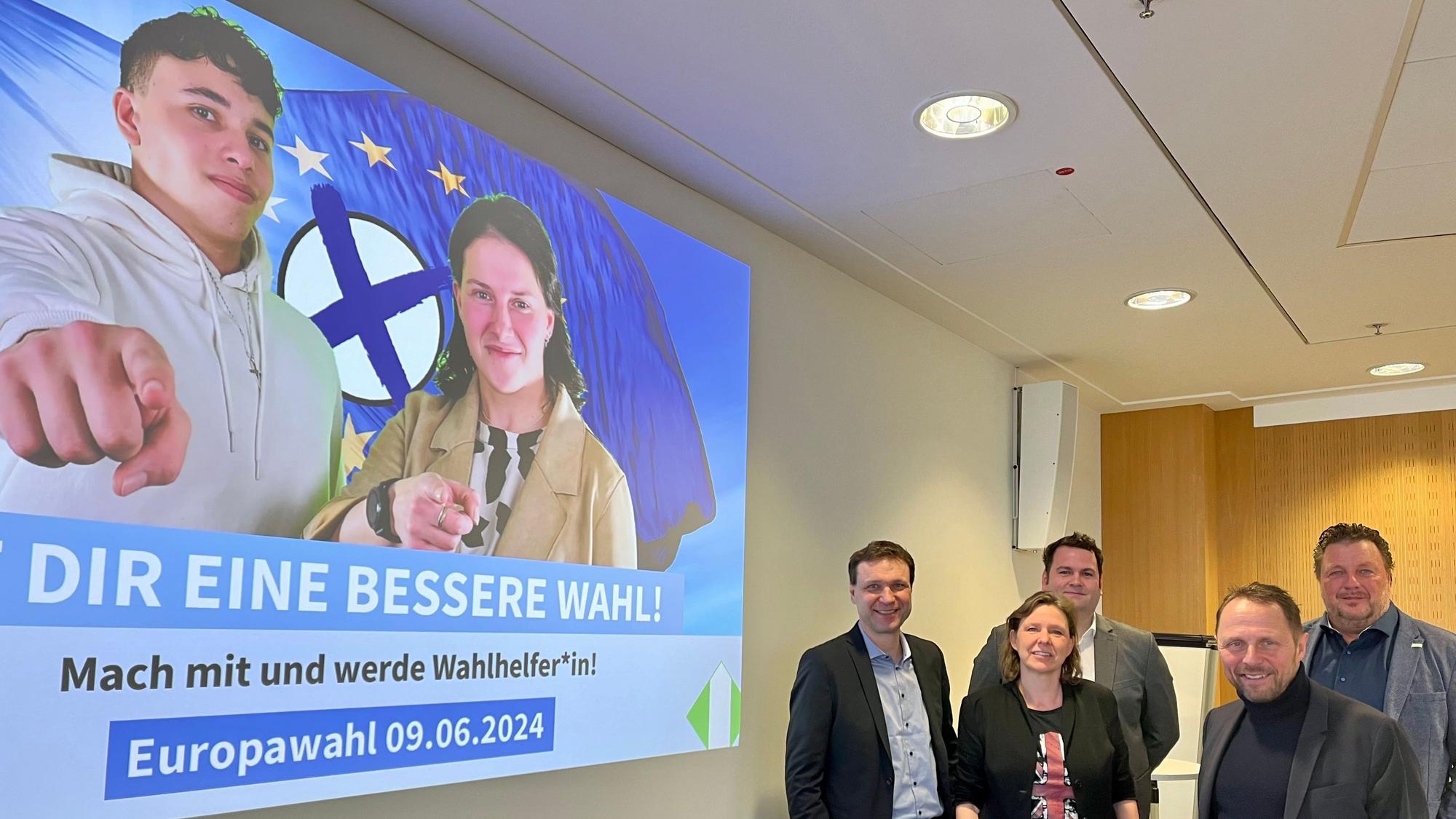 Dezernent Alexander Lünenbach, Britta Meyer, Severin Schipp, OB Uwe Richrath und Oliver Gäcke, dr Leiter des Fachbereichs Bürger und Integration vor einer Leinwand mit der Europawahl-Kampagne