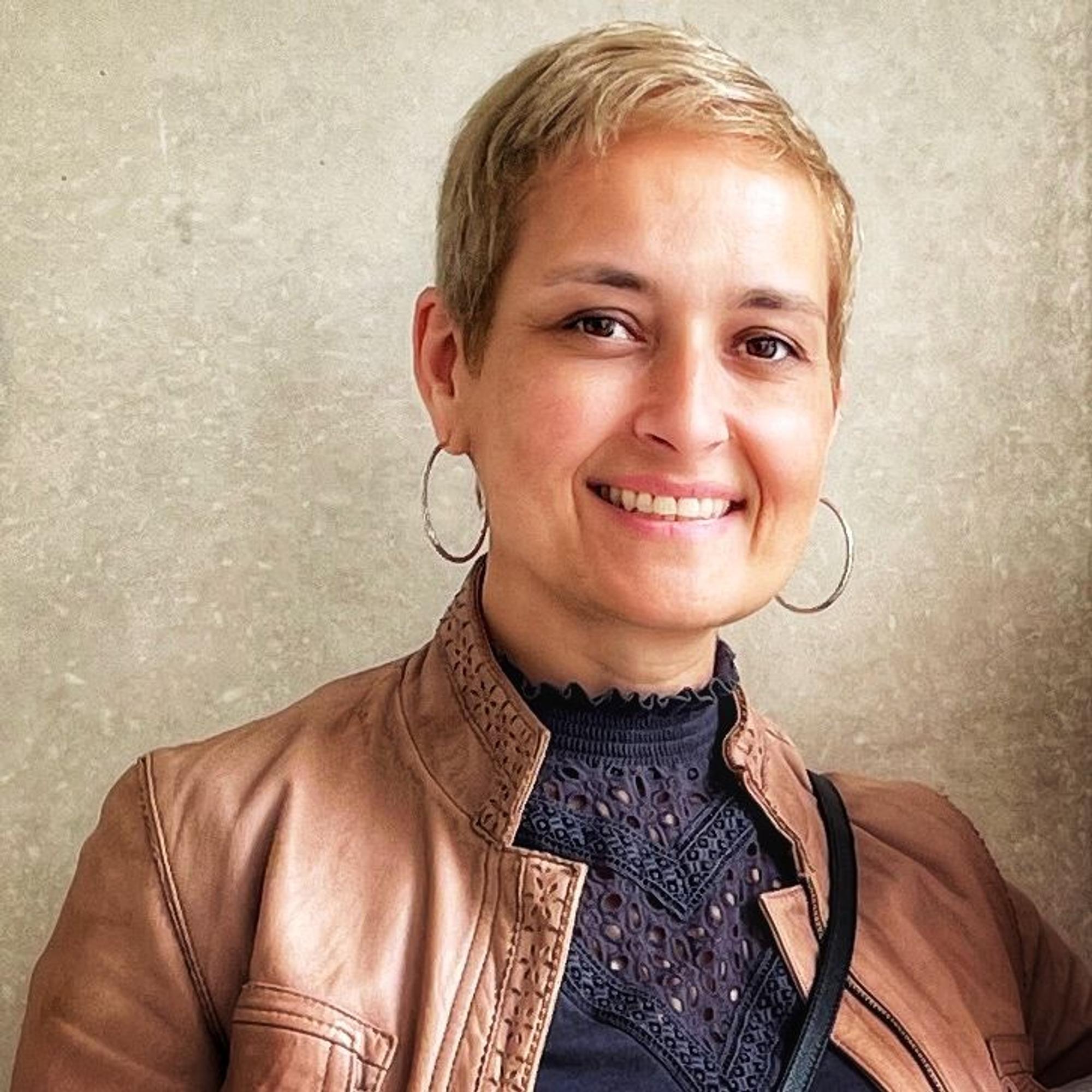 Andrea David, Reisebloggerin, ist im Porträt zu sehen. Sie lächelt in die Kamera.