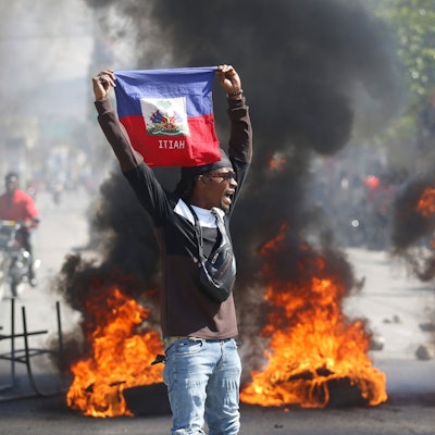 Ein Demonstrant hält eine haitianische Flagge während Protesten für den Rücktritt von Premierminister Henry hoch.