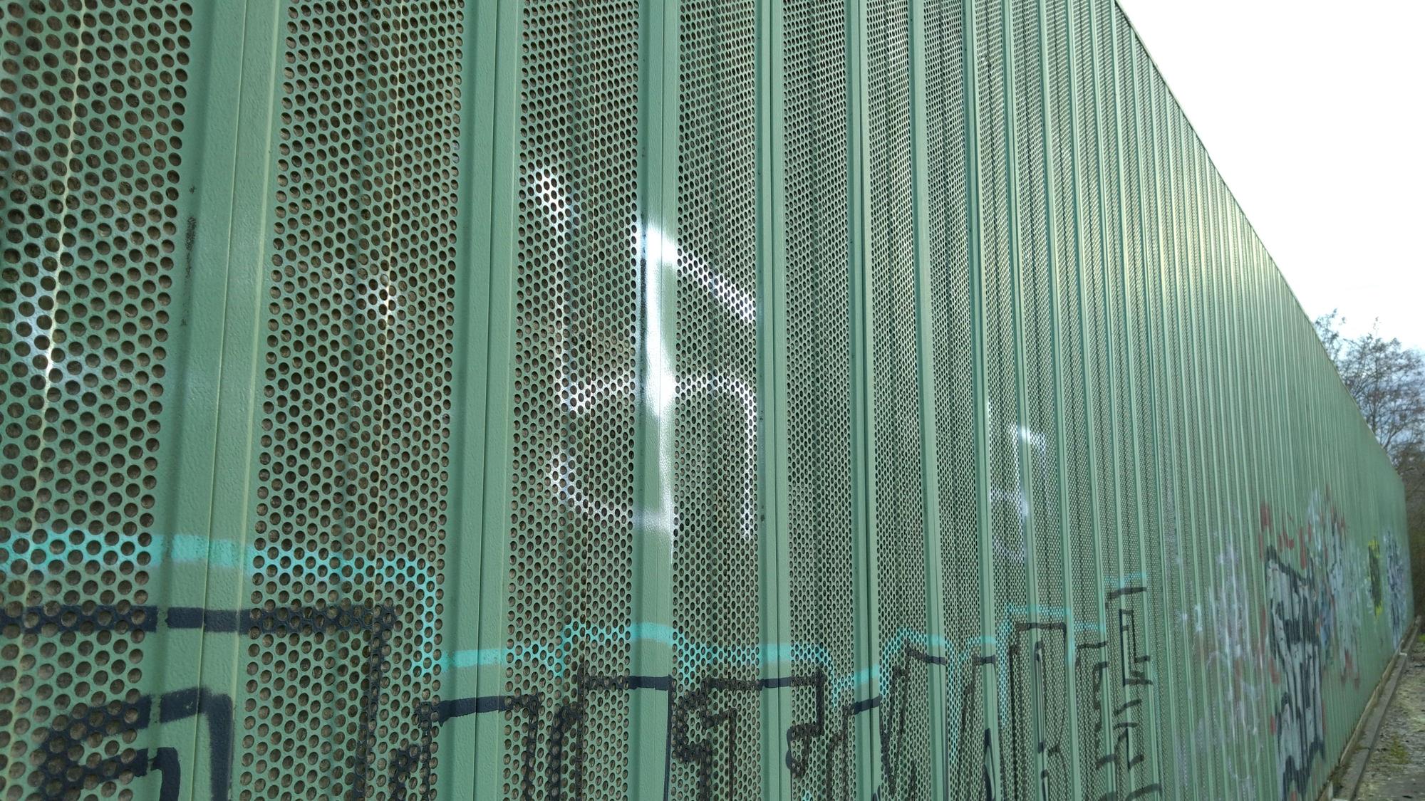 Ein aufgemaltes Hakenkreuz auf einer Lärmschutzwand.