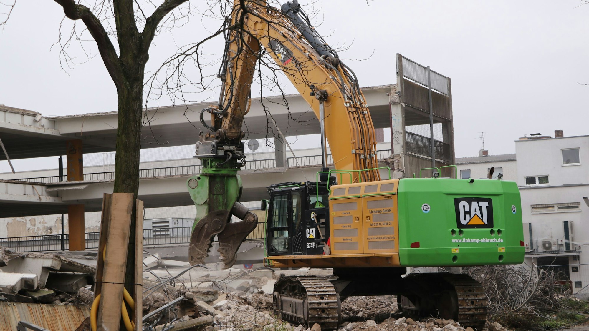 Der Greifer eines riesigen Baggers zerkleinert Beton.