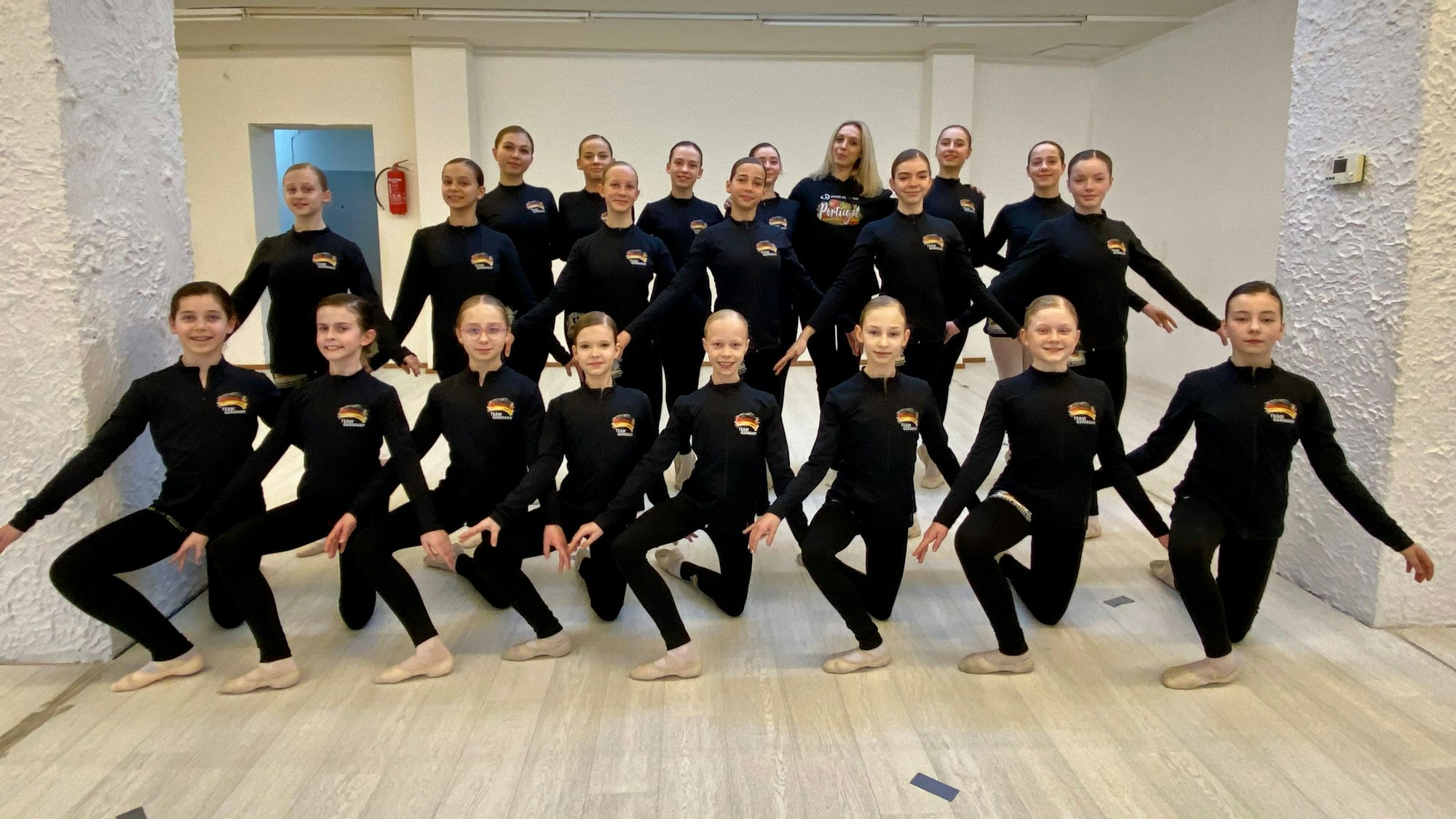 Eine Gruppe von jungen Tänzerinnen in schwarzen Outfits.