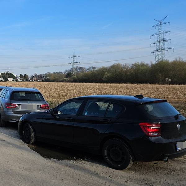 Autos parken am Feldrand