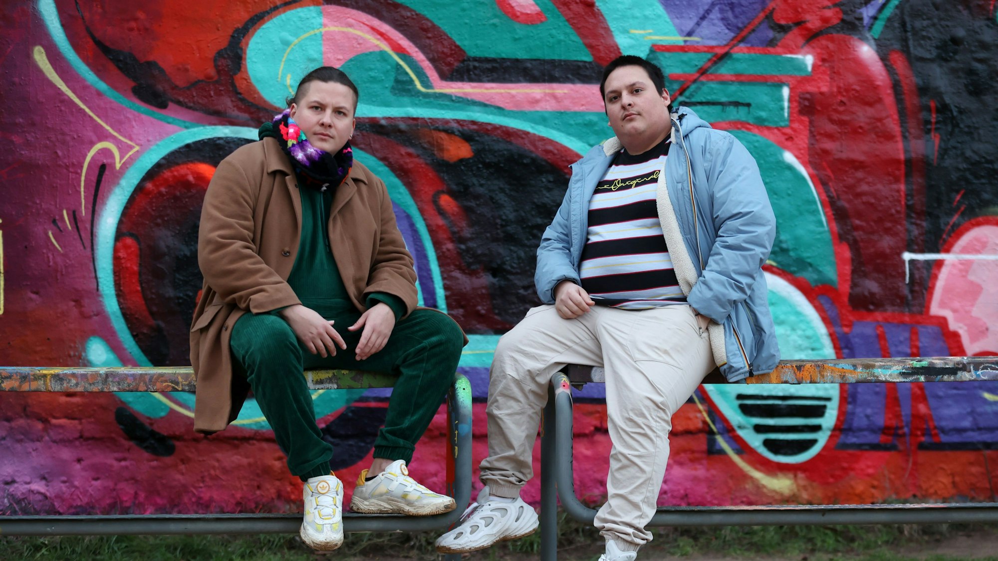 Inti und Chaski Ayvar Waltz vor einer bemalten Wand