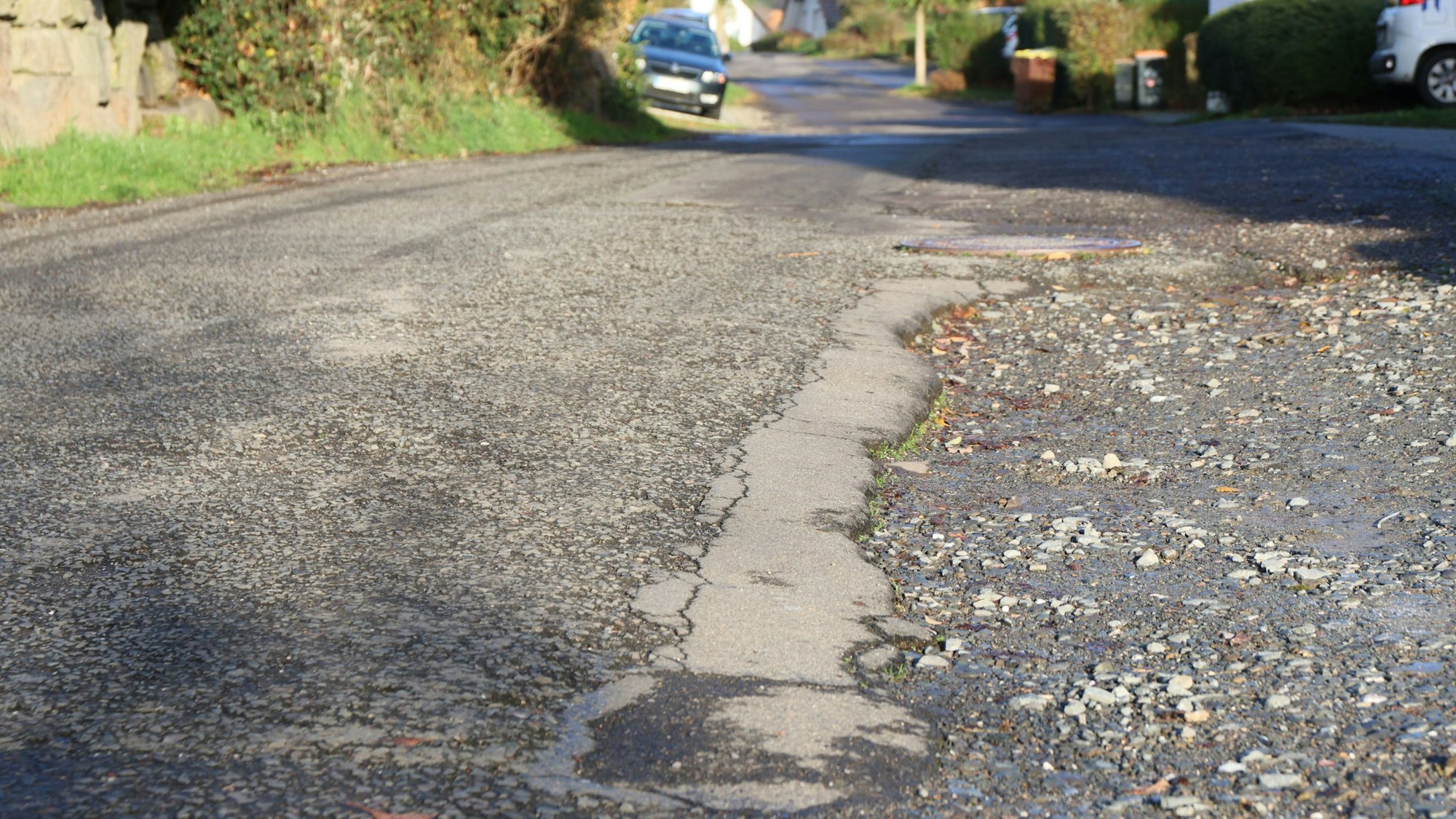 Blick auf Straße mit kaputter Straßendecke.