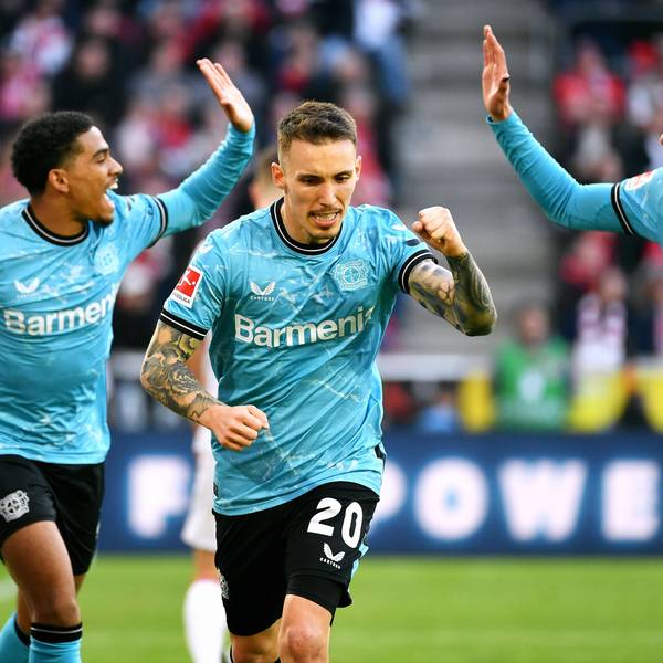 Alejandro Grimaldo (m.) jubelt nach seinem Tor zum 0:2 gegen den 1. FC Köln. Hinter ihm sind Amine Adli (l.) und Borja Iglesias (r.) im Begriff, mit Händen einzuschlagen.