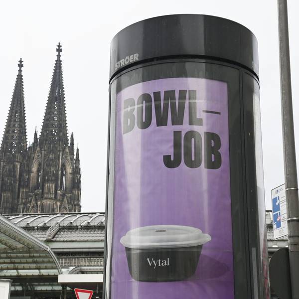 Plakate auf einer Litfaßsäule mit dem Kölner Dom im Hintergrund: Das Kölner Unternehmen Vytal warb mit dem Kunstwort „Bowljob“ für seine Mehrwegbehälter, auf die nicht direkt Pfand gezahlt werden muss.