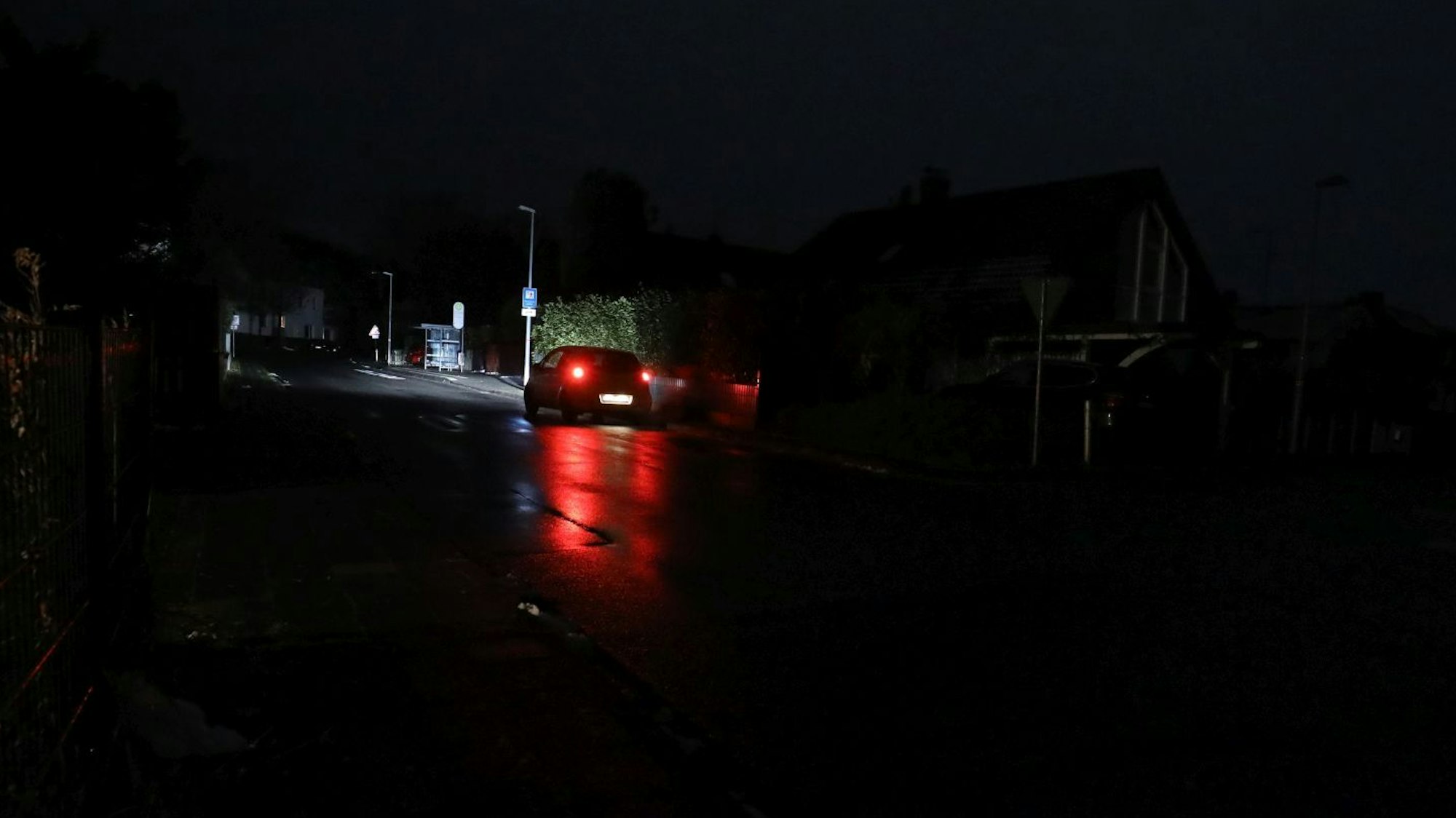 Ein Auto fährt über eine dunkle Straße in Königswinter, nur die Scheinwerfer sorgen für ein bisschen Licht.
